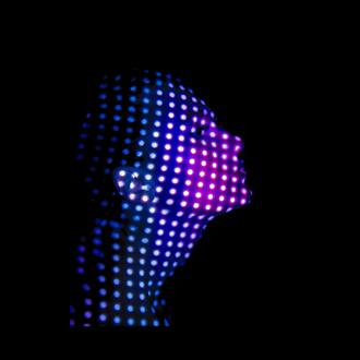 Woman's face covered in dots of light against a black background.
