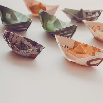 Origami boats made out of paper currency from various countries 
