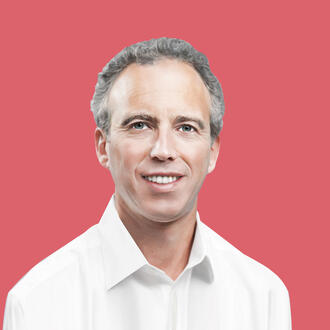 Frederic Kerrest, co-founder, executive vice chairman, identity management company Okta, smiles at the viewer, over a pink-red background