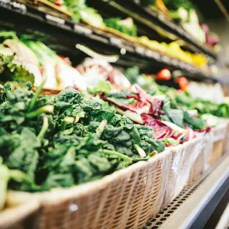 Market shelf with baskets of leafy produce