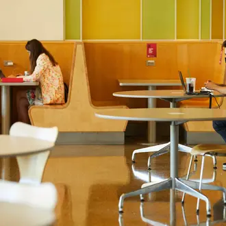 A photo of masked students working on laptops in MIT Sloan while socially distanced.