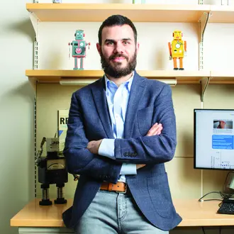 David Rand standing in front of desk