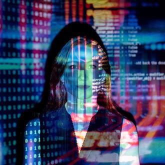 Image of a woman, with images of computer coding superimposed on her face and behind her
