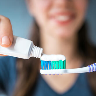 Woman squeezing toothpaste onto toothbrush