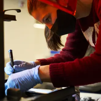 LGO student Lisa Schleuter taking apart 3D printer