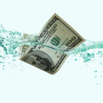 A hundred dollar bill floats in water