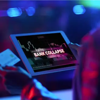 person holding tablet with BANK COLLAPSE on the screen