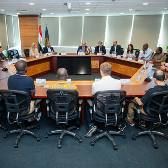Group of people sitting around a circular table at a meeting