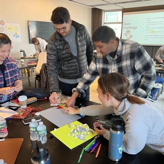Group of entrepreneurs in classroom working on a project together at a table