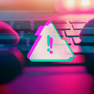 A person types on a keyboard with a malware virus alert