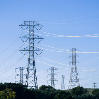 Electrical transmission towers and lines against a blue sky