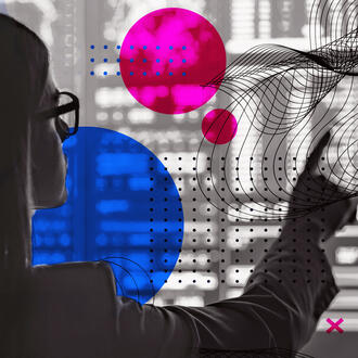 A worker points to a screen covered in code and geometric shapes