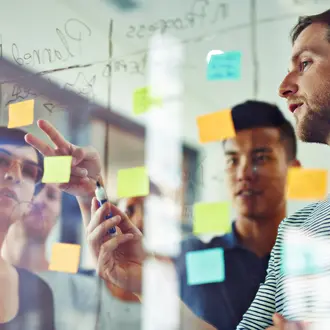 A team working on a glass board with sticky notes