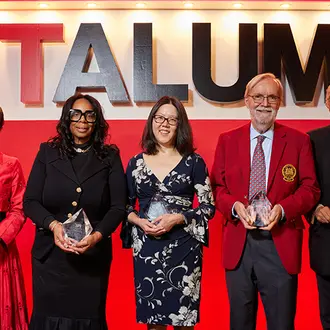 Group of people stands on stage holding awards