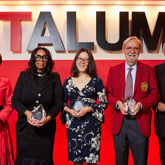 Group of people stands on stage holding awards