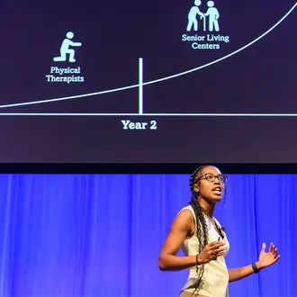 Qadence startup presents on stage at MIT Delta V Demo Day