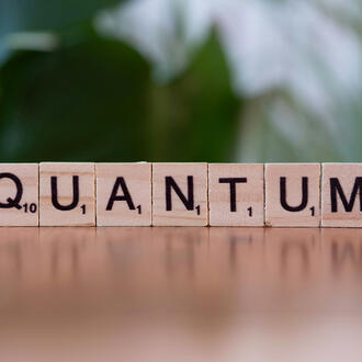 Scrabble pieces spell out the word "Quantum"