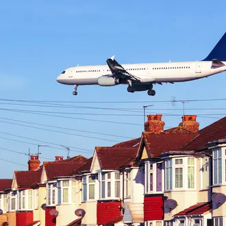 An airplane flies low over a neighborhood