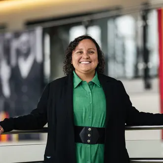 Solangel Fernandez in a green dress and black sweater