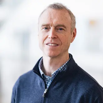 David Miller in front of blurry white background