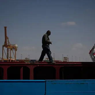 A worker walks on the deck of a feeder vessel as he works to offload cargo of rice into trucks at Umm Qasr Port, a deep-water port, in the city of Umm Qasr, Iraq, Friday, March 27, 2026.