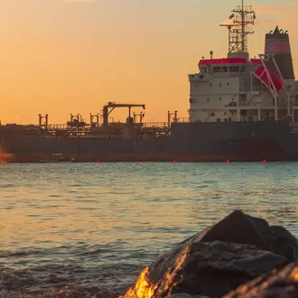 View of a Large Tanker on the Sea near a Shore at Sunset
