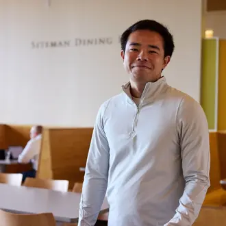 student stands in Sloan cafe