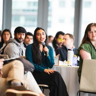 ClimateCAP attendee holding microphone in audience