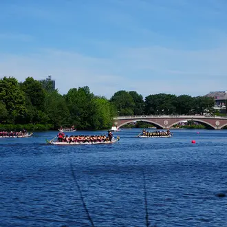 Several boats race down the Charles River in Cambridge