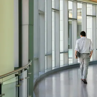 Man walking on the indoor bridge connecting building E62 with E52.