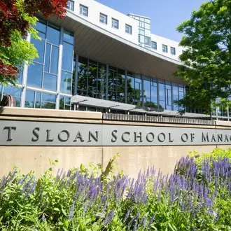 Exterior photo of MIT Sloan's main building E62 with plants