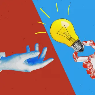 A human hand and a robot hand holding a lightbulb