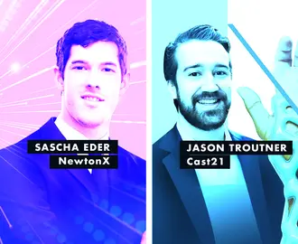 two men smiling in front of a pink and blue background