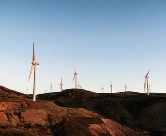 Photo of dozens of wind turbines on rocky landscape.