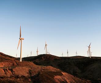 Photo of dozens of wind turbines on rocky landscape.