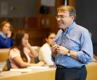 Bertismas standing in front of a students.