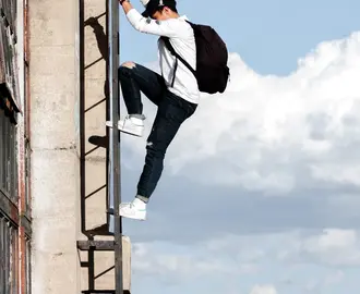 Image of a Man With Backpack Climbing a Ladder
