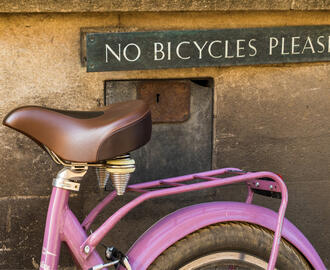 A bicycle resting on a "no bicycle please" sign 