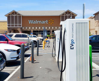 Several EVgo fast charging electric vehicle recharging stations in a Walmart parking lot.