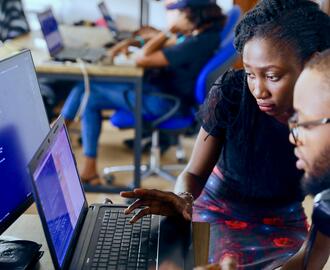 Two people looking at computer screens