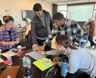 Group of entrepreneurs in classroom working on a project together at a table
