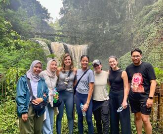 Photo of G-Lab team in front of a waterfall