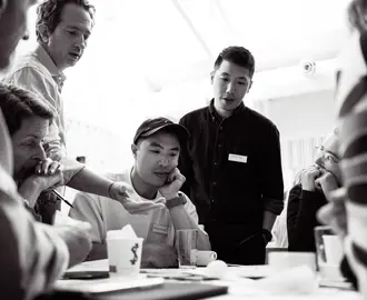 Black and white photo of Jason and Alban Yau with participants in the Investing for Systems Change program
