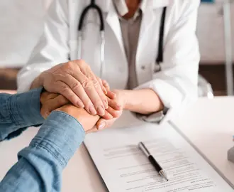 Doctor patient grasping hands