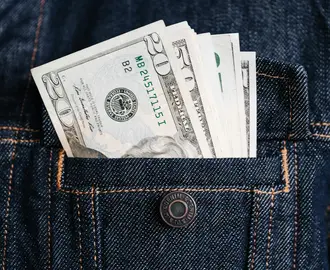 Image of a denim jacket's pocket, with money in it