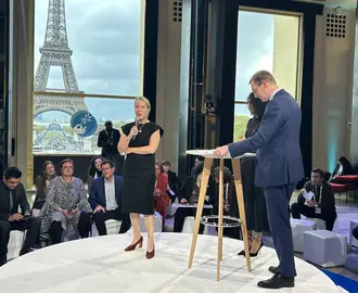 MIT Climate Policy Center Executive Director Bethany Patten Presents at the Paris Peace Forum. Eiffel Tower visible through window in background