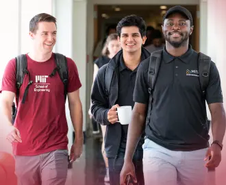 Three LGO students walk through the hallways of MIT Sloan