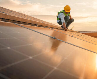 A person does work on a solar roof