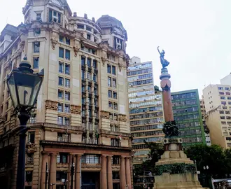 A tall building with a statue in front of it. 