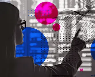 A worker points to a screen covered in code and geometric shapes